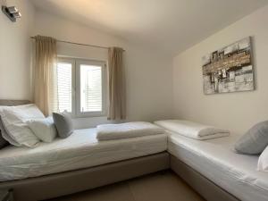 two beds in a room with a window at Holiday House Laura in Vir +30 photos