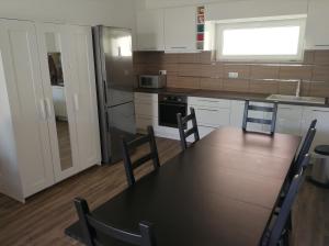 een keuken met een tafel en stoelen en een keuken met een koelkast bij ZR9 in Zamárdi