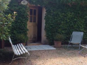 two chairs sitting in front of a house with a door at Atelier Soleil in Moustiers-Sainte-Marie +6 photos