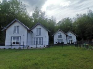 a group of three white houses in a field at Leśne Zacisze w Nadolu in Nadole