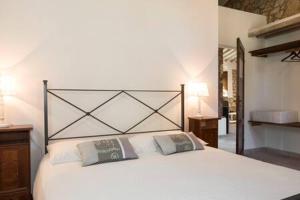 una camera con un letto bianco con due cuscini di Podere La Castellina a Podere Poggiaccio Altre 43 foto