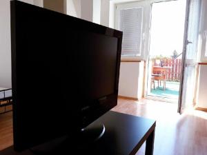 a flat screen tv sitting on a table in a living room at Apartment Patera in Unhošť