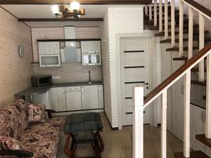 a living room with a couch and a kitchen and stairs at Апартаменти Олівія in Skhidnitsa