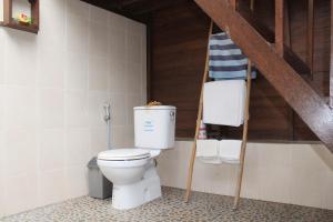 a bathroom with a toilet with a ladder and towels at MolaMola House in Nusa Lembongan
