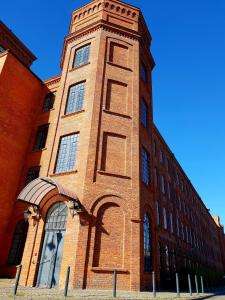 a brick building with a tower on the side of it at Loft Suite in Łódź