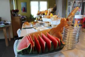a table with a plate of watermelon sandwiches on it at Villa Saffels Nest in Lochristi