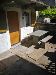 a picnic table and bench outside of a building at Rustico Il Pardo in Maggia