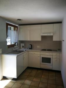 a kitchen with white cabinets and a sink and a stove at Rustico Il Pardo in Maggia