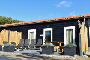 una casa negra con mesa de picnic y sillas en Appartement zeldenrust, en Oostkapelle