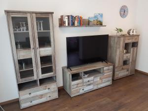 a entertainment center with a television and two book shelves at harle-casa.ostfriesland in Altfunnixsiel