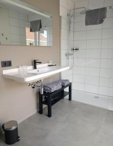 uma casa de banho com um lavatório e um chuveiro em B & B De Veurnse Slaper em Veurne