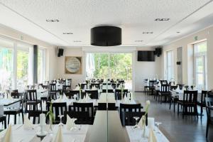 un comedor con mesas y sillas blancas en Beisenbusch Hotel & Restaurant en Bottrop