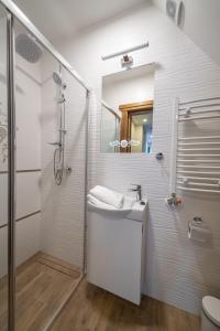 a white bathroom with a sink and a shower at Willa Góralski Styl in Bukowina Tatrzańska