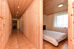 ein großes Holzzimmer mit einem Bett darin in der Unterkunft Stainiškių slėnis in Aviliai