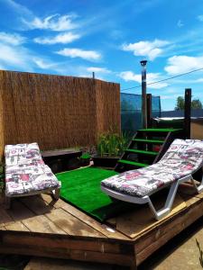 a deck with two chairs and a green lawn at Relax and chill Villa in Chornomorsk