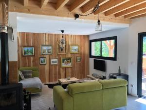 ein Wohnzimmer mit einem Sofa und einem Tisch in der Unterkunft Villa Marcassin in Boulc