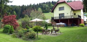 una casa con mesa, sillas y sombrilla en U Agnieszki, en Krynica-Zdrój