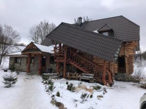 a log cabin with snow on the ground at Будинок Художника Шипіт in Pilipets