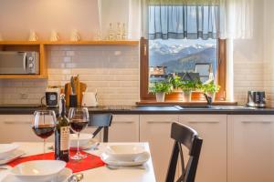 une cuisine avec une table et deux verres de vin dans l'établissement Apartamenty ROZETA - ZAKOPANE, à Zakopane