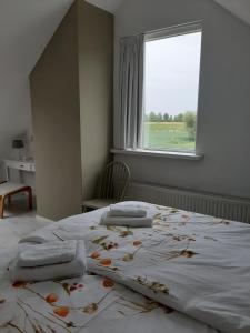 una camera da letto con un letto grande con asciugamani sopra di Vakantiewoning Het Olietunnetje a Ovezande