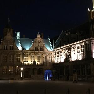 um grande edifício com luzes acesas à noite em B & B De Veurnse Slaper em Veurne