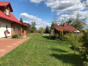un patio junto a una casa con techo rojo en Miodunka, en Dubicze Osoczne