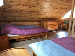 a log cabin bedroom with two beds and a dresser at Miodunka in Dubicze Osoczne