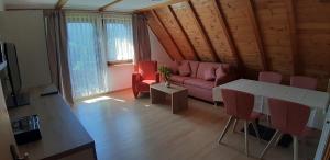 a living room with a couch and a table and chairs at Martina Frey Ferienwohnungen in Baiersbronn