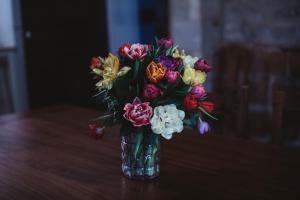 Gites chez Antonin في تورْ دو فورْ: إناء من الزهور جالس على طاولة