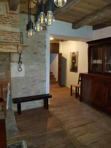 a living room with a stone wall and a bench at Gites chez Antonin in Tour-de-Faure