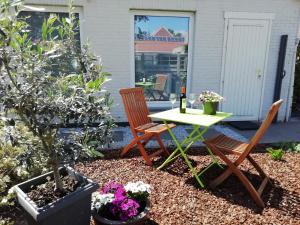 a patio with a table and chairs and flowers at The Mill 2380 in Ravels
