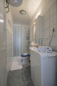 a white bathroom with a toilet and a sink at Apartment Filomena in the center in Komiža