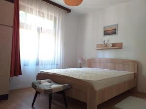 a bedroom with a large bed and a window at Balatonszemesi Nyaralóház in Balatonszemes