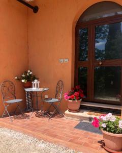 a patio with a table and chairs next to a door at La Casa all'Oliveto in Pitigliano