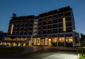 un grand bâtiment avec des lumières devant lui dans l'établissement Avar Hotel, à Matrafured