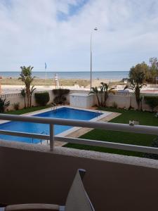 a view of a swimming pool and the beach at Apartamento primera linea junto al puerto in Denia