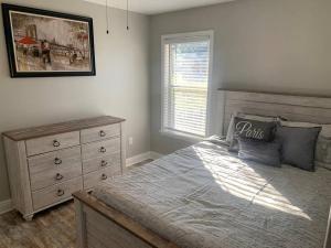 a bedroom with a bed and a dresser and a window at Villas at Valencia Bay in Gulfport
