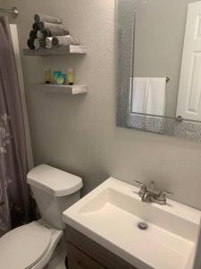 a bathroom with a sink and a toilet and a mirror at Villas at Valencia Bay in Gulfport