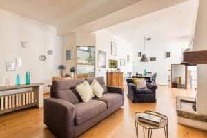 ein Wohnzimmer mit einem Sofa und einem Tisch in der Unterkunft Refined flat with private loggia in San Frediano in Florenz