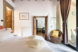 ein Schlafzimmer mit einem weißen Bett und einem Stuhl in der Unterkunft Refined flat with private loggia in San Frediano in Florenz
