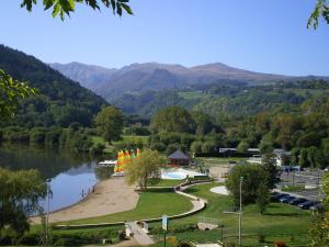 a park with a lake and mountains in the background at Logis Hôtel Restaurant SPA le Beau Site in Chambon-sur-Lac