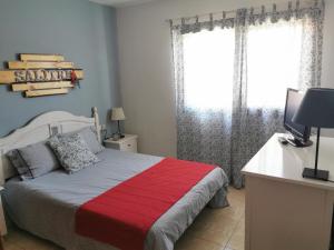 a bedroom with a bed and a desk with a television at Salitre in La Caleta