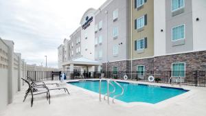 un hotel con piscina di fronte a un edificio di Candlewood Suites Waco, an IHG Hotel a Waco