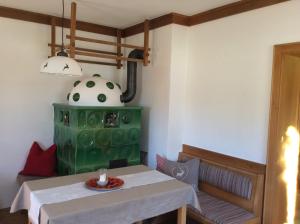 ein Esszimmer mit einem Tisch und einem grünen Herd in der Unterkunft Untermühlbauer Fam. Schreder in Saalfelden am Steinernen Meer