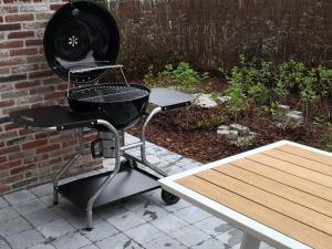 a grill sitting on a cart next to a table at Newport House in Nieuwpoort