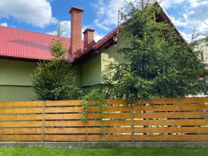 a wooden fence in front of a house at Apartament w Twardorzeczce in Sienna