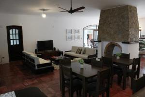 Una sala de estar con una mesa y una chimenea. en Casa da Uba Una, en Ubatuba