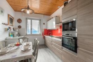 a kitchen with a table and a kitchen with red at Casa Heli I in San Zeno di Montagna