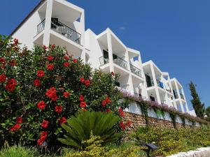 a white building with red flowers in front of it at The Desmais in Cala Galdana