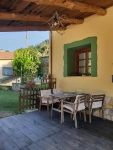 a patio with a table and chairs on a house at Casa Rural La Pumarada de Limés in Cangas del Narcea